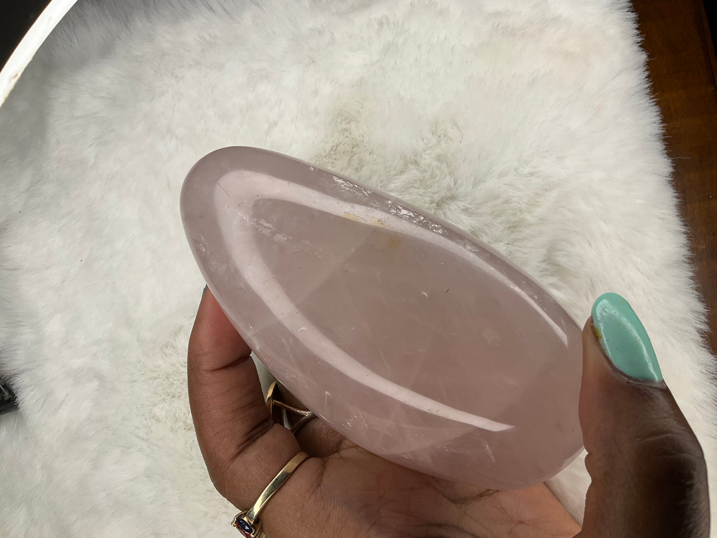 rose quartz in a half oval shape with a rounded point in a deep pink with rainbows 